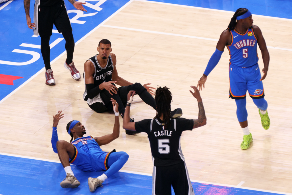Oklahoma City Thunder guard Shai Gilgeous-Alexander (2), guard Luguentz Dort (5), San Antonio Spurs forward Victor Wembanyama (1) and guard Stephon Castle (5) react after a foul call during the second half of Game 1 in a third-round NBA basketball playoffs series Monday, May 18, 2026, in Oklahoma City. (AP Photo/Nate Billings)