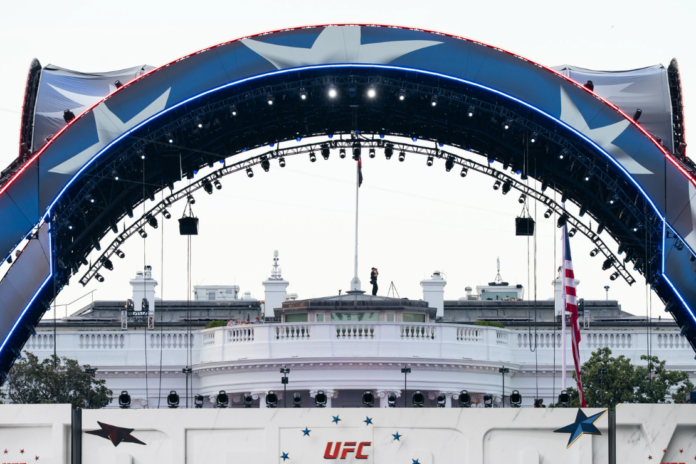 Security at the White House looks through a pair of binoculars during the UFC Fan Fest on the White House Ellipse ahead of Sunday's fight on the South Lawn, June 13, 2026, in Washington. (AP Photo/Allison Robbert, File)