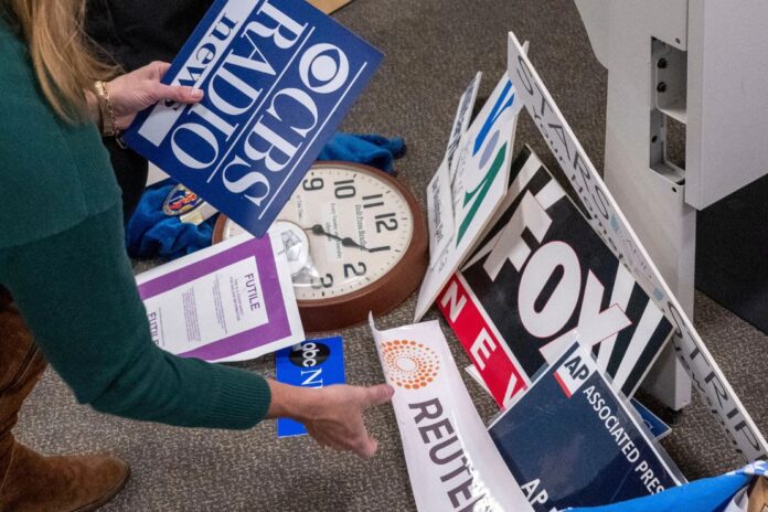 Washington Post reporter Tara Copp saves the name plaques from various news organizations as she and members of the media pack up their belongings in the press area in the Pentagon, Oct. 15, 2025 in Washington. (AP Photo/Kevin Wolf, File)