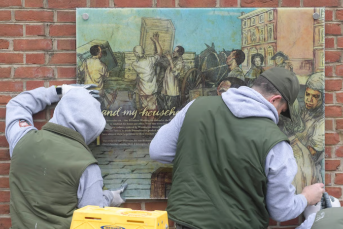 Staff with the National Parks Service replace the plaques that were part of the 'Freedom and Slavery in the Making of a New Nation' exhibit at the President's house on February 19, 2026 in Philadelphia, Pennsylvania. (Photo by Matthew Hatcher/Getty Images)