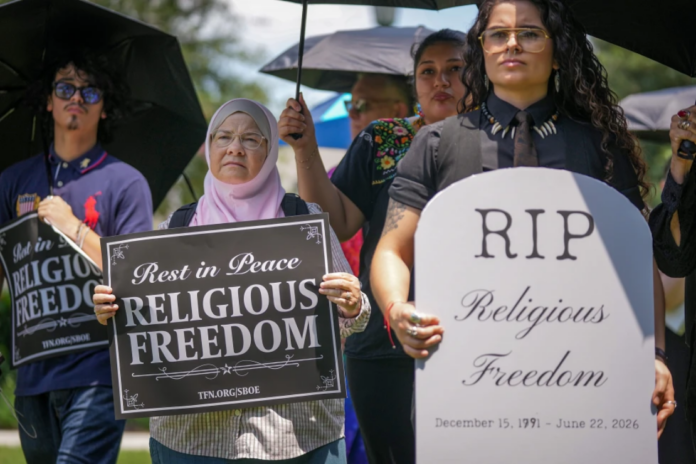 Ruth Nasrullah, left, and Rocio Fierro-Perez, political director for the Texas Freedom Network, participate in an interfaith funeral-themed protest outside the Barbara Jordan Building in Austin on Monday, June 22, 2026. (Jay Janner/Austin American-Statesman via AP)