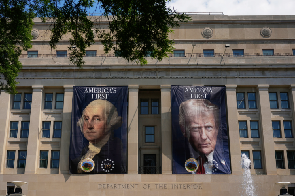 Banners, one of President George Washington that reads "America's First," left, and another of President Donald Trump that reads, "America First," are pictured at the Department of the Interior, Thursday, June 25, 2026, in Washington. (AP Photo/Carolyn Kaster)