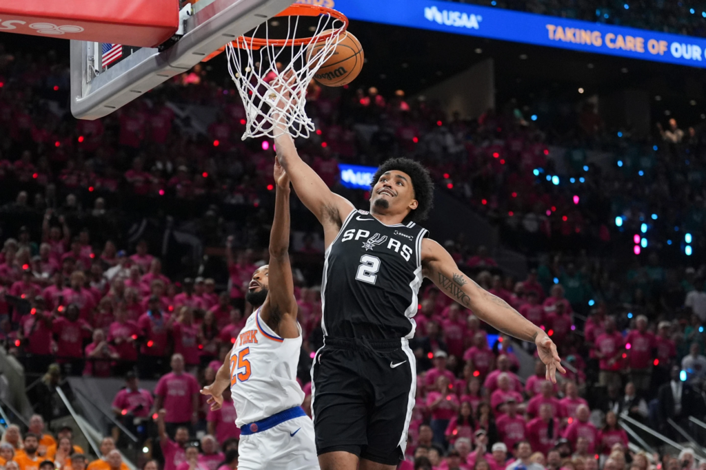 San Antonio Spurs guard Dylan Harper (2) is fouled by New York Knicks guard Mikal Bridges (25) during the first half of Game 1 of the NBA Finals basketball series, Wednesday, June 3, 2026, in San Antonio. (AP Photo/Eric Gay)