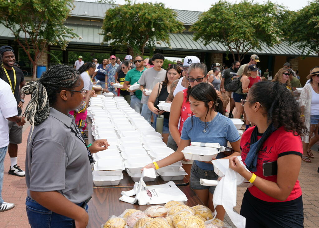 About 300 attendees received barbecue chicken, sausage, fruit and vegetables following the Junior Chef Competition at Mission County Park on July 18, 2026. (Photo by Burrell Parmer)