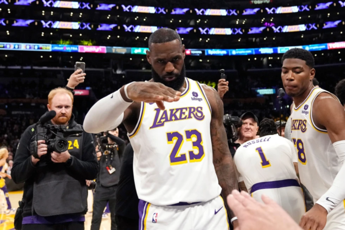 Los Angeles Lakers forward LeBron James salutes public address announcer Lawrence Tanter prior to an NBA basketball game against the Denver Nuggets Saturday, March 2, 2024, in Los Angeles. (AP Photo/Mark J. Terrill,File)