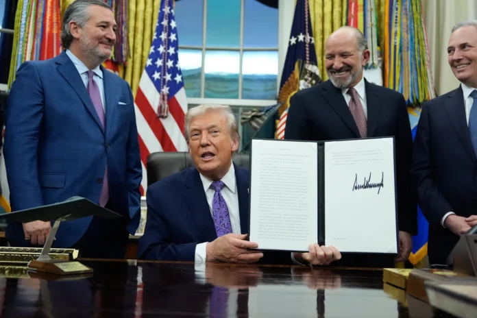 Flanked by Sen. Ted Cruz, R-Texas, left, Secretary of Commerce Howard Lutnick, second right, and White House AI and Crypto Czar David Sacks, President Donald Trump displays his signed AI initiative in the Oval Office of the White House, Dec. 11, 2025, in Washington. (AP Photo/Alex Brandon, File) Flanked by Sen. Ted Cruz, R-Texas, left, Secretary of Commerce Howard Lutnick, second right, and White House AI and Crypto Czar David Sacks, President Donald Trump displays his signed AI initiative in the Oval Office of the White House, Dec. 11, 2025, in Washington. (AP Photo/Alex Brandon, File)