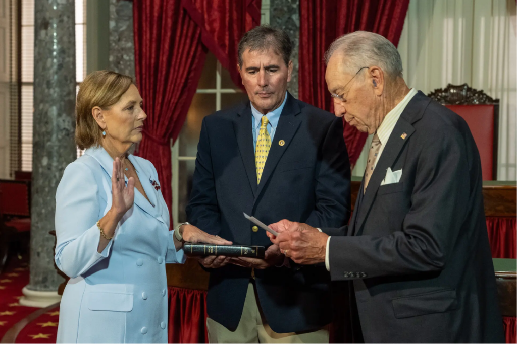 Darline Graham being sworn in by Senator Charles E. Grassley on Tuesday as her husband, Larry Nordone, holds a Bible.Credit...Alex Kent/The New York Times