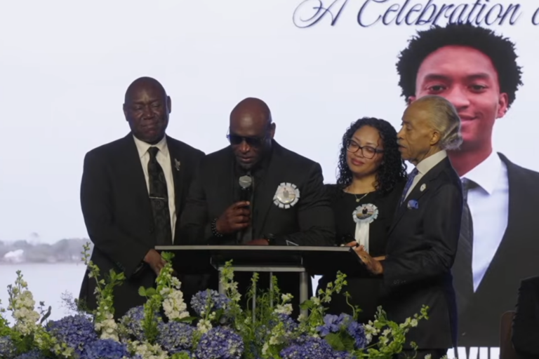 Ben Crump, Rev. Al Sharpton, and Nolan Wells parents at Wells funeral, July 20, 2026. (Screenshot)