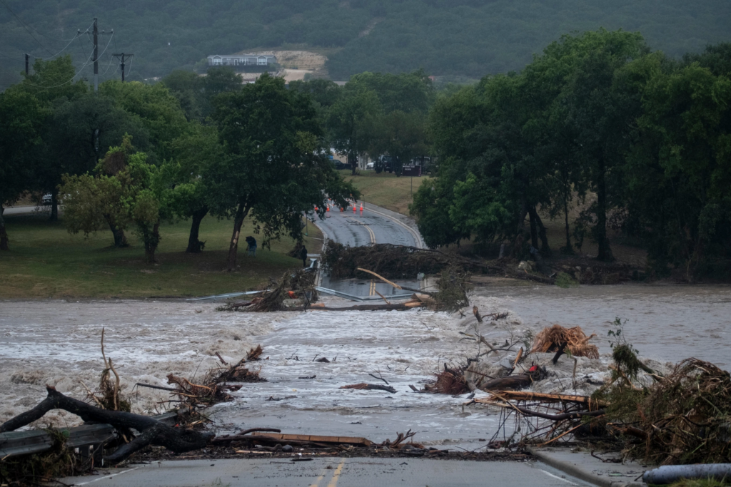 Flooding blocks off G Street along the Guadalupe River on Thursday, July 16, 2026, in Kerrville, Texas. Experts say climate change is intensifying extreme weather events, making them more frequent and severe. Recent flash floods in Texas highlight this trend. (AP Photo/Joel Angel Juarez)