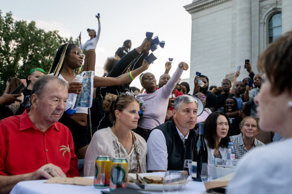 Protesters approach attendees of a Concerts on the Square event July 22, 2026, in Madison, Wis, after a Madison man was shot and killed by a police officer earlier that day. (Angela Major / WPR)