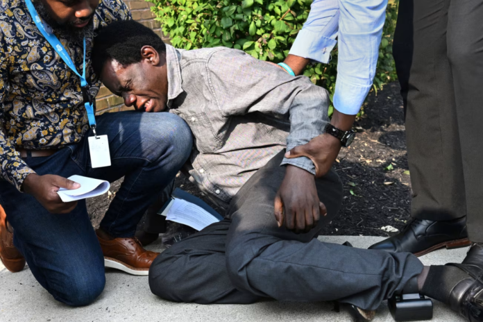 After receiving an ankle monitor during a check-in Sunday at an ICE field office in Blue Ash, Ohio, Haitian immigrant Monsanto Maler became emotional and collapsed outside. Carol Guzy