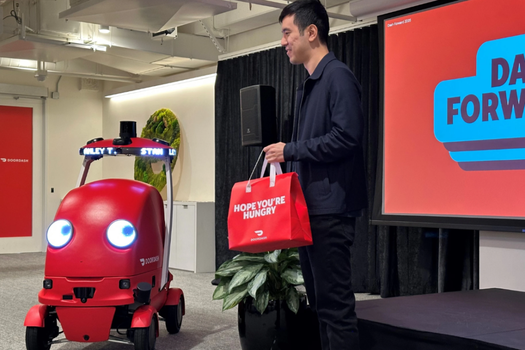 DoorDash co-founder Stanley Tang fetches a food delivery from a new delivery robot called Dot on Sept. 29, 2025, at DoorDash headquarters in San Francisco. (AP Photo/Michael Liedtke)